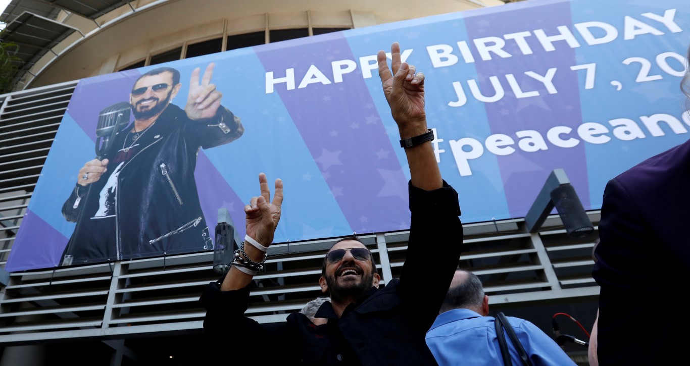 Ringo Starr gestures to fans at a "Peace & Love" event to celebrate his 77th birthday in Los...