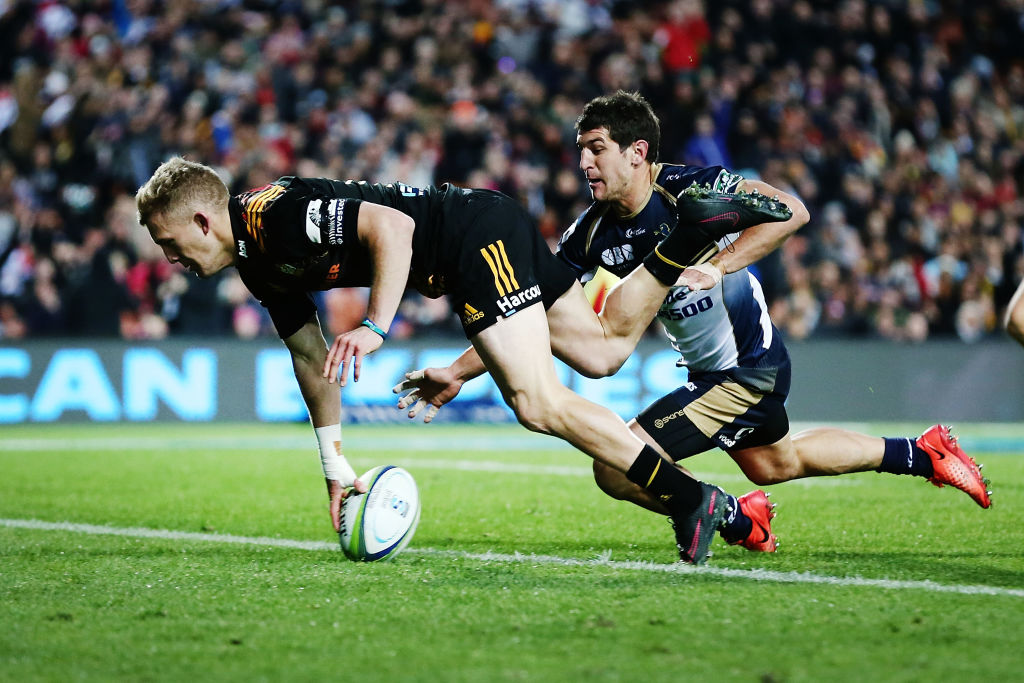 Damian McKenzie of the Chiefs scores a try against Tomas Cubelli of the Brumbies . Photo: Getty