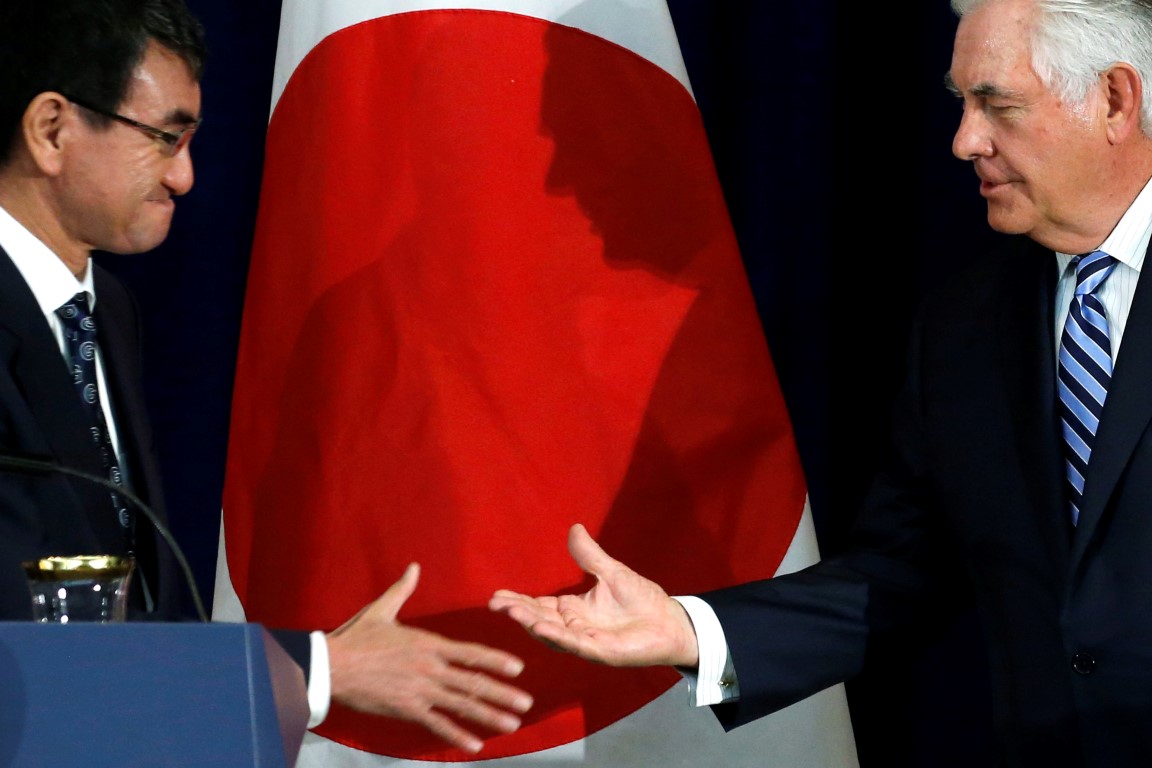 Japan's Foreign Minister Taro Kono (L) and US Secretary of State Rex Tillerson shake hands...