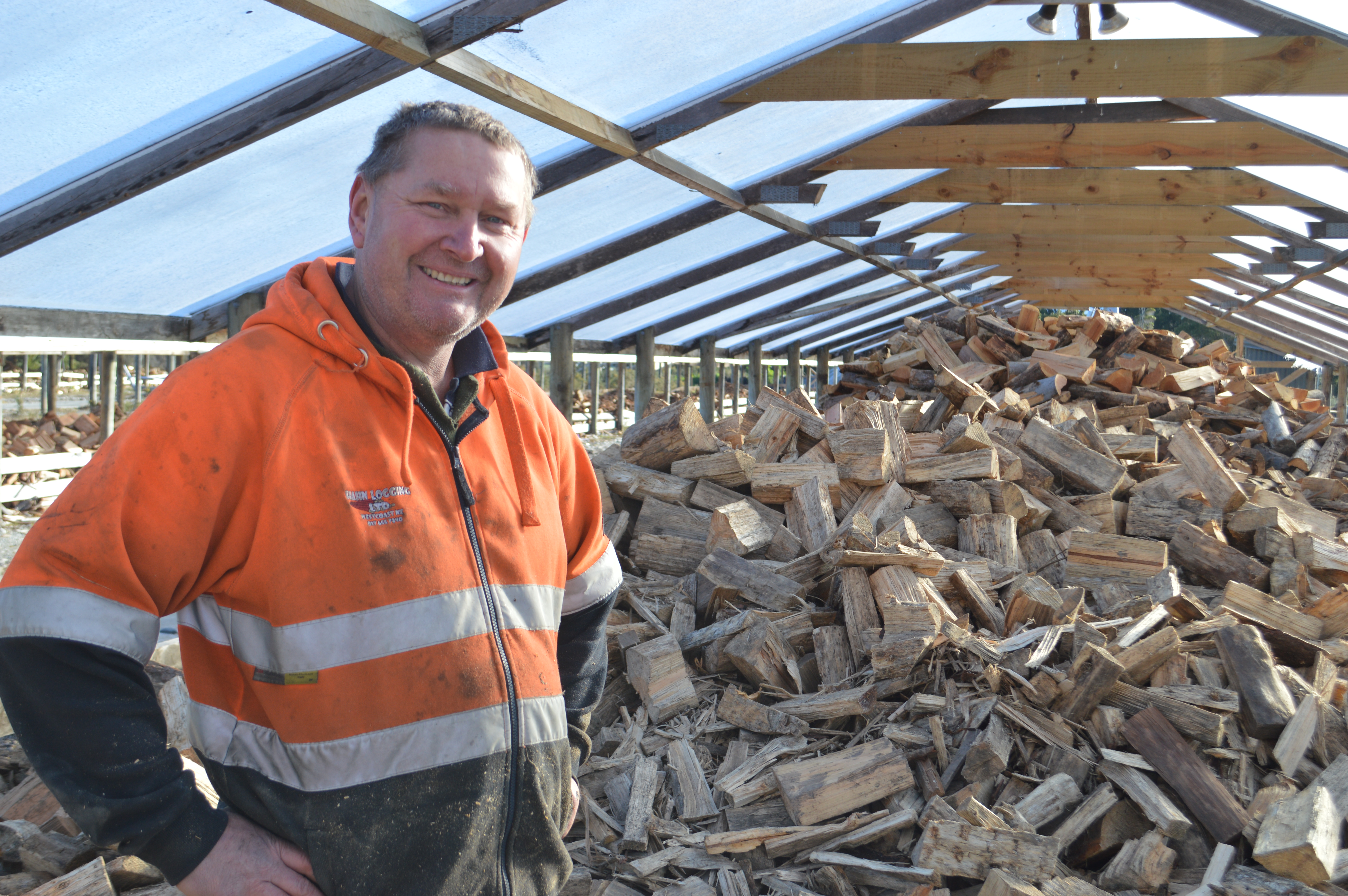 Ken Bee with a stock of kiln-dried firewood in a tunnel house at H and H Firewood and Coal. Photo...