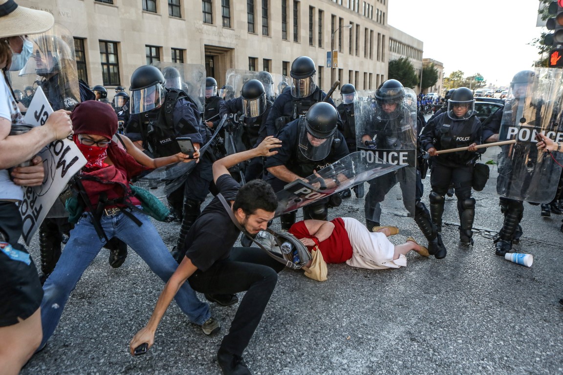 Protesters are pushed back by riot police during a demonstration following a not guilty verdict...