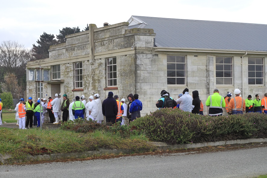 Pukeuri employees wait for the all-clear at the meatworks site this morning after a fire led to...