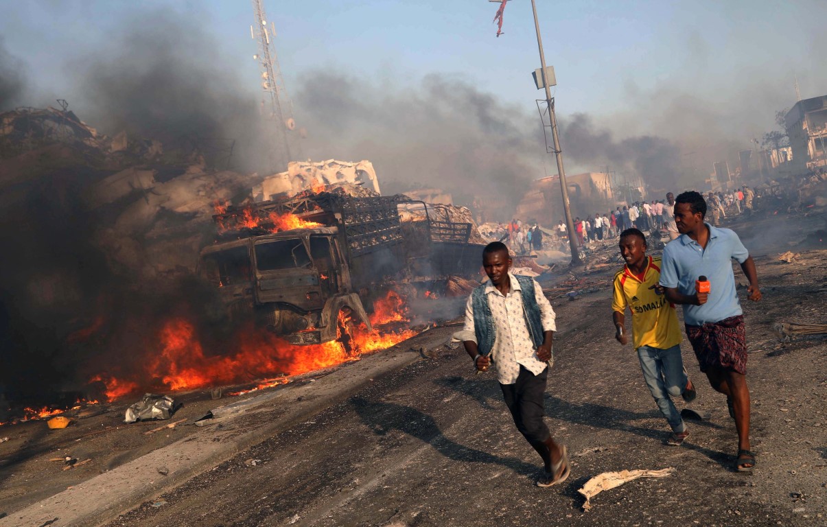 People run from the scene of one of the blasts in the Hodan district of Mogadishu. Photo Reuters 
