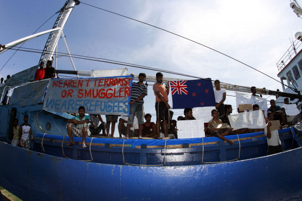 Sri Lankan refugees hold signs and plead for assistance as they seek asylum in New Zealand in...