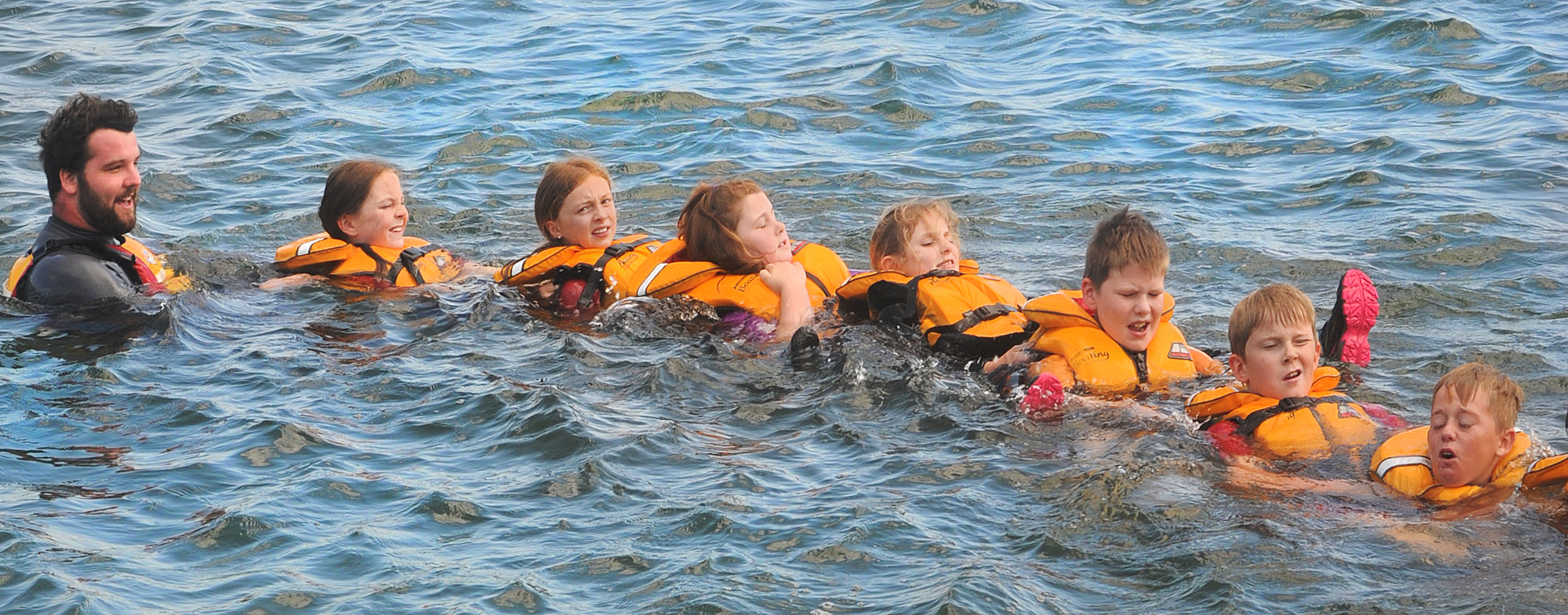 As part of their water safety programme, Swimsation instructor Ben Harrison and (from left) Imogen Harrison (10), Melanie Button (10), Grace Gemmell (9), Harmony Denston (10), James Scott (9), Ben Thompson (9) and Robbie Smith (10) form a rescue train in 