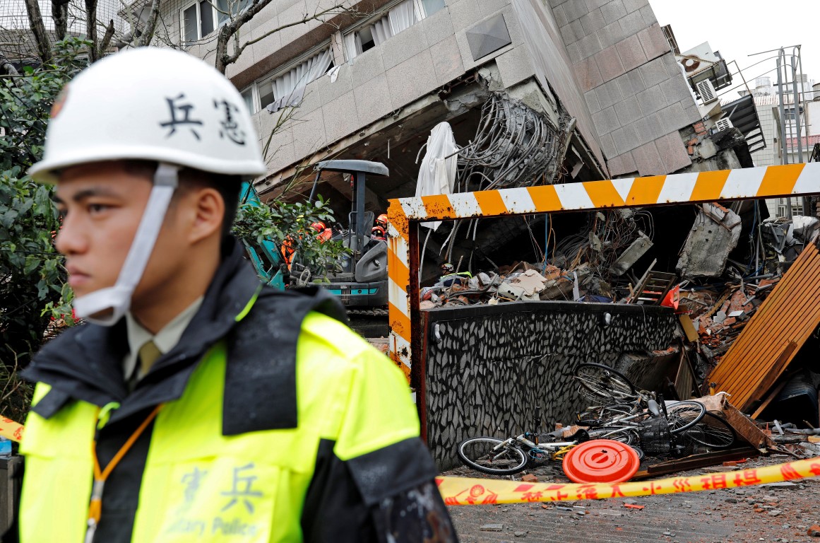 Military police stand guard outside a collapsed building in Hualien, Taiwan. Photo: Reuters