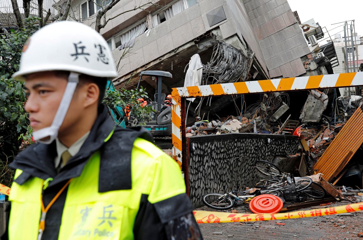 Military police stand guard outside a collapsed building in Hualien, Taiwan. Photo: Reuters
