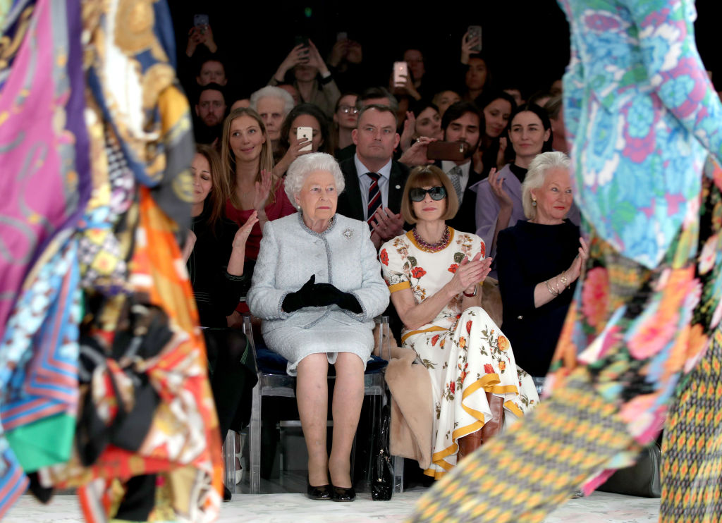 Queen Elizabeth II sits next to Vogue Editor-in-Chief Anna Wintour as they view Richard Quinn's...