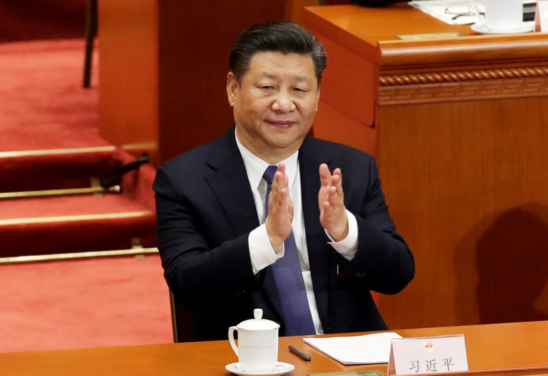 Chinese President Xi Jinping applauds after the parliament passed a constitutional amendment...
