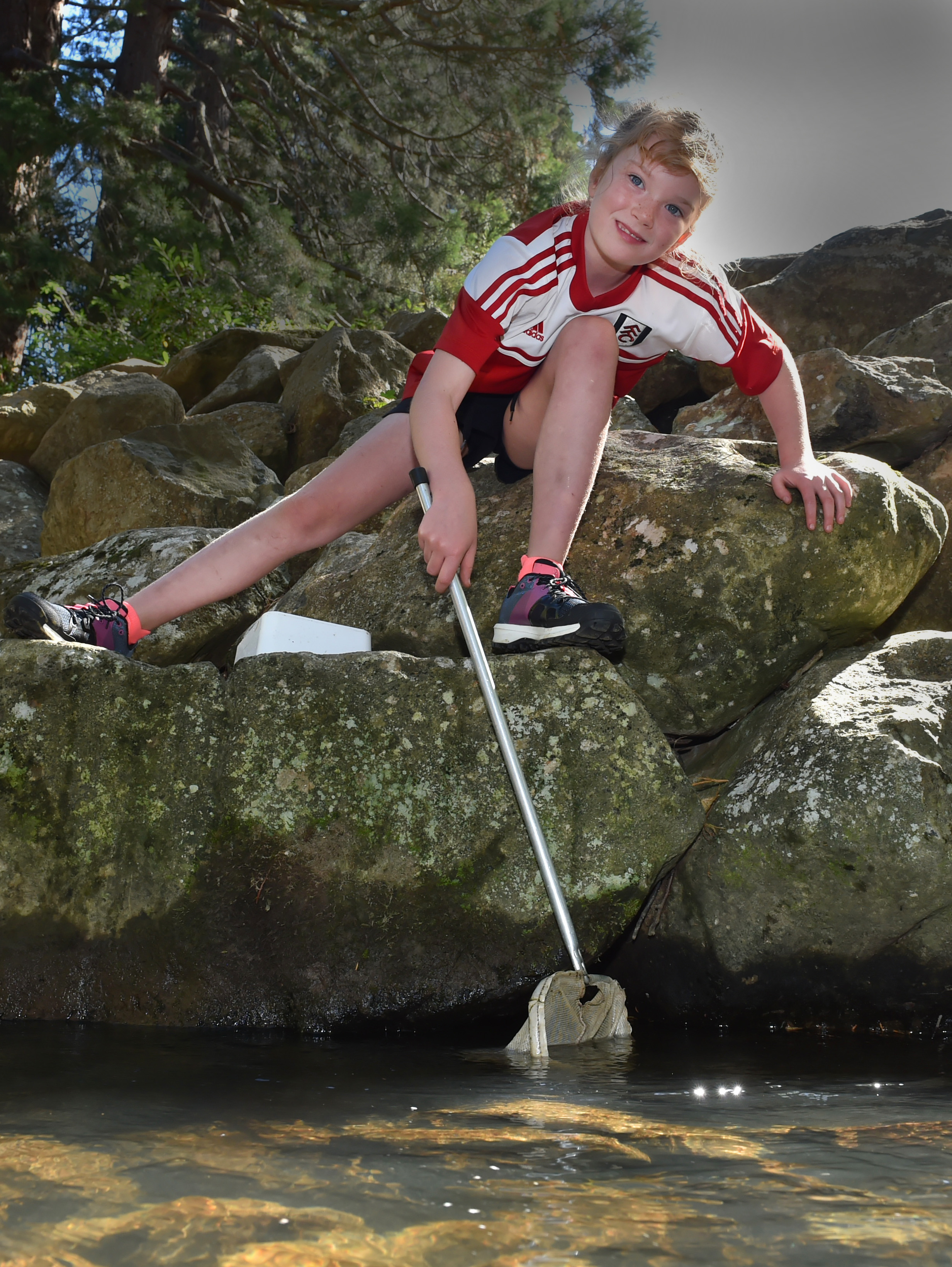Billie Fraser (8) attempts to net creatures in Lindsay Creek as part of CreekFest in Chingford...