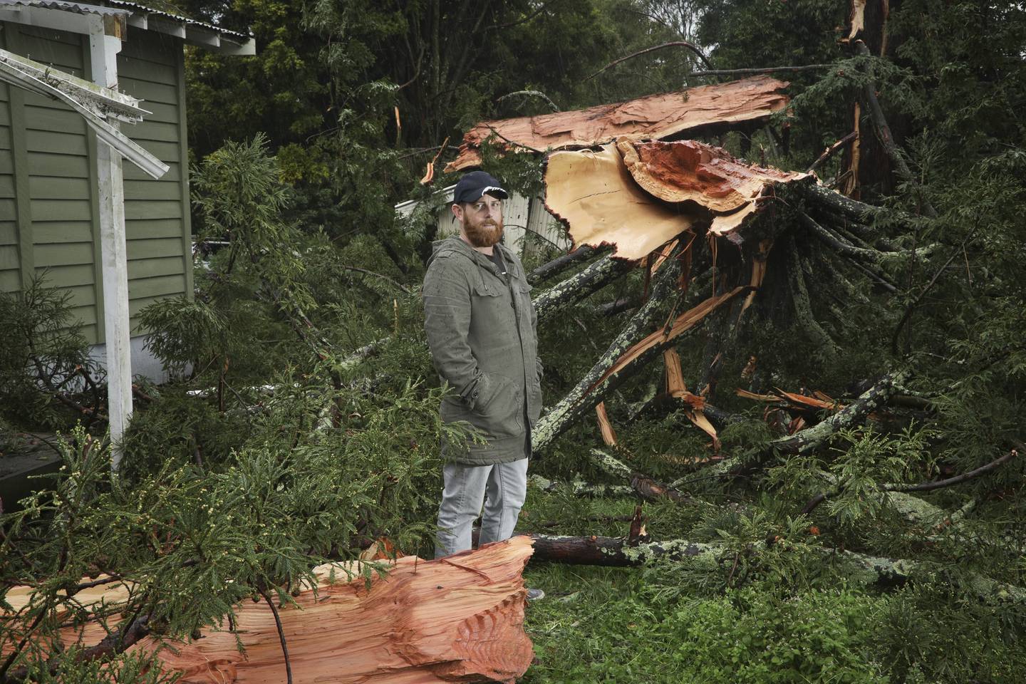 Matt Petuha in front of his family's rented Te Puke home beside the remains of a tree struck by...
