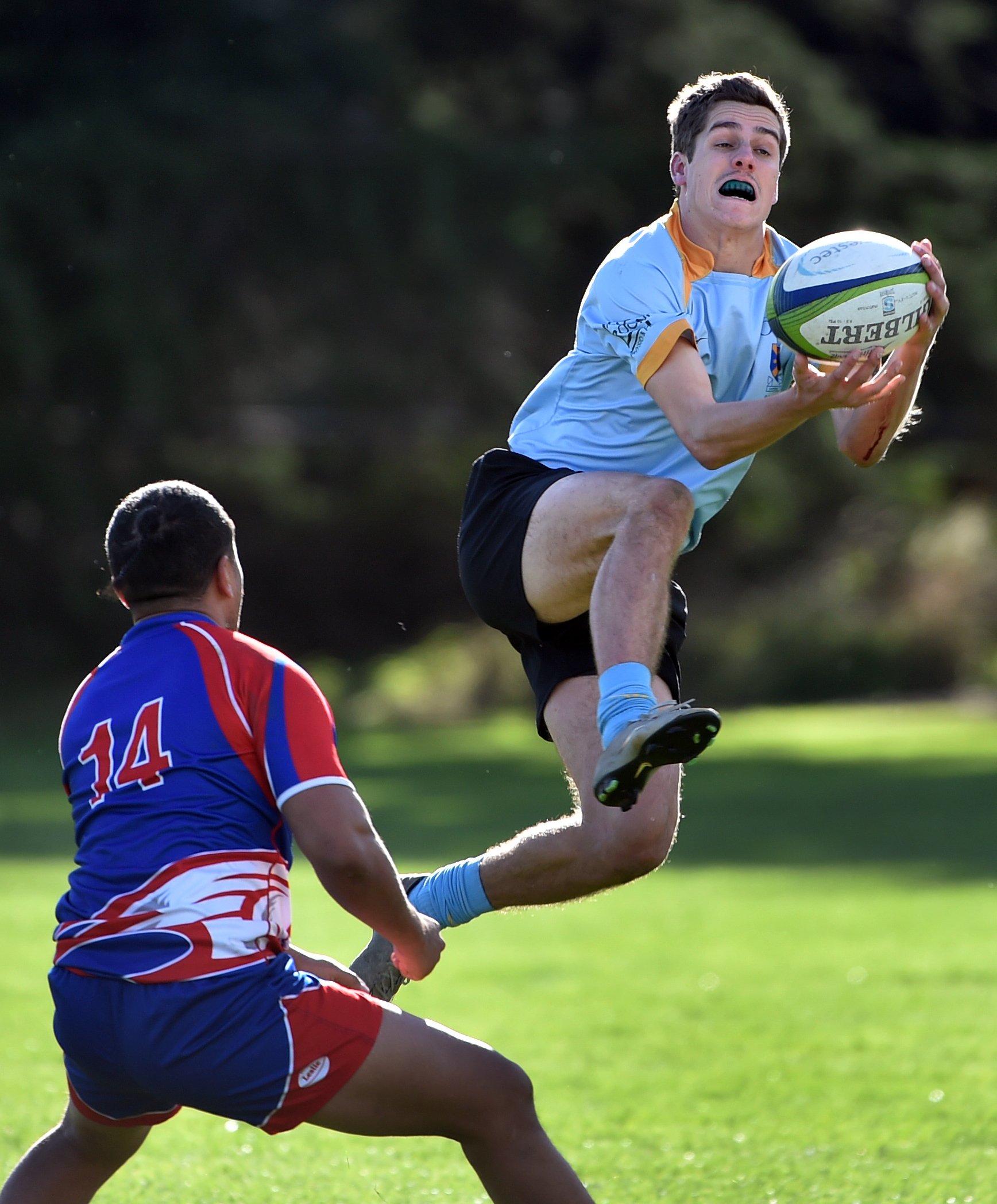 University winger Cam Gerlach catches the ball while Harbour winger Ngana Nicholas looks to...