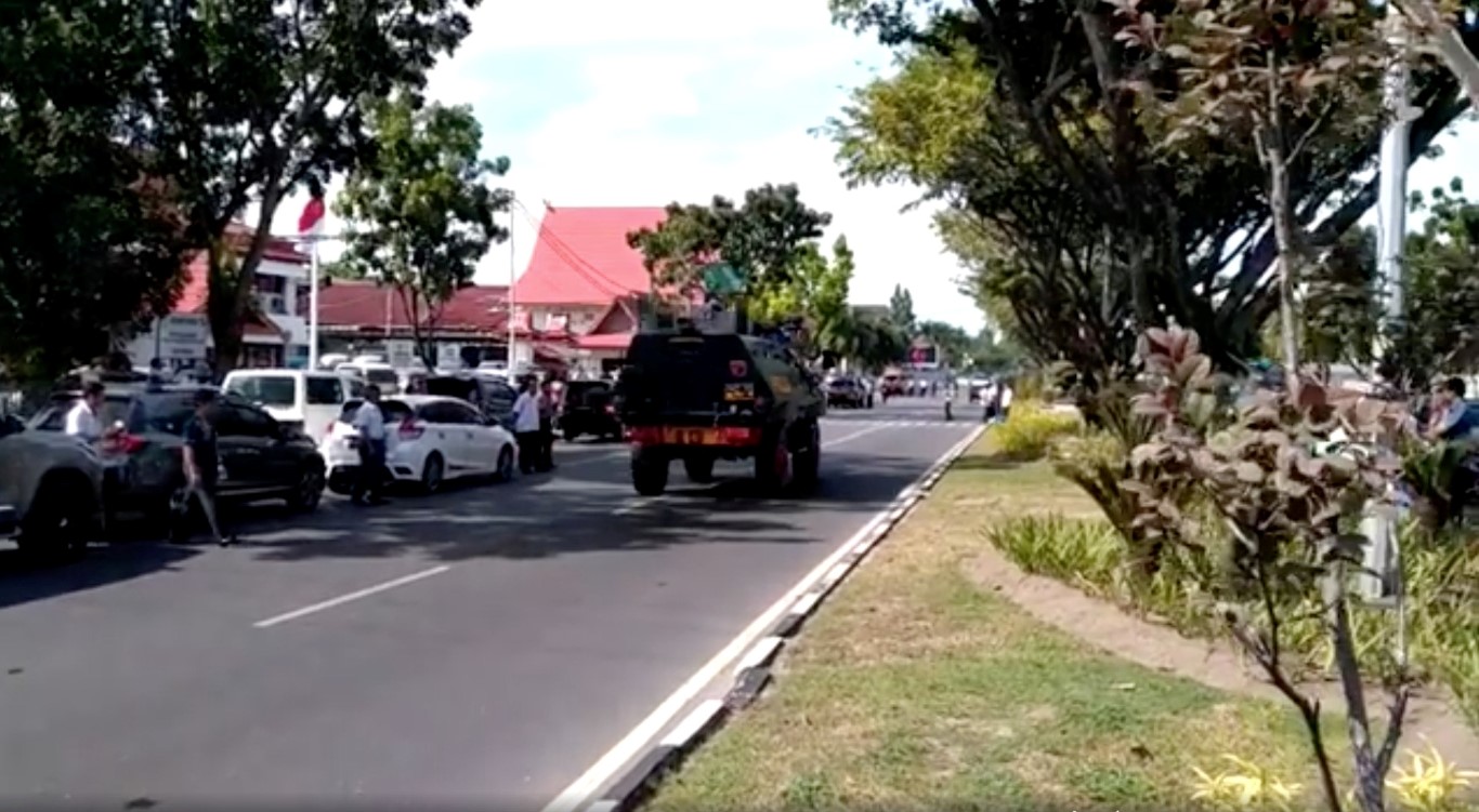 A security vehicle is driven along a road after an attack at the Riau police headquarters