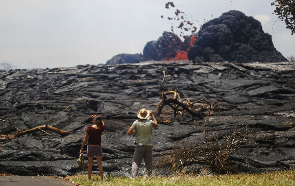 People watch as lava erupts from a Kilauea volcano fissure in Leilani Estates, on Hawaii's Big...