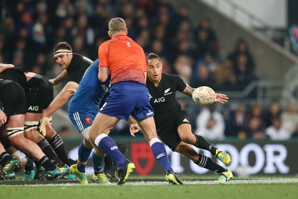 France's Baptiste Serin is blocked by referee John Lacey as All Black halfback Aaron Smith passes...