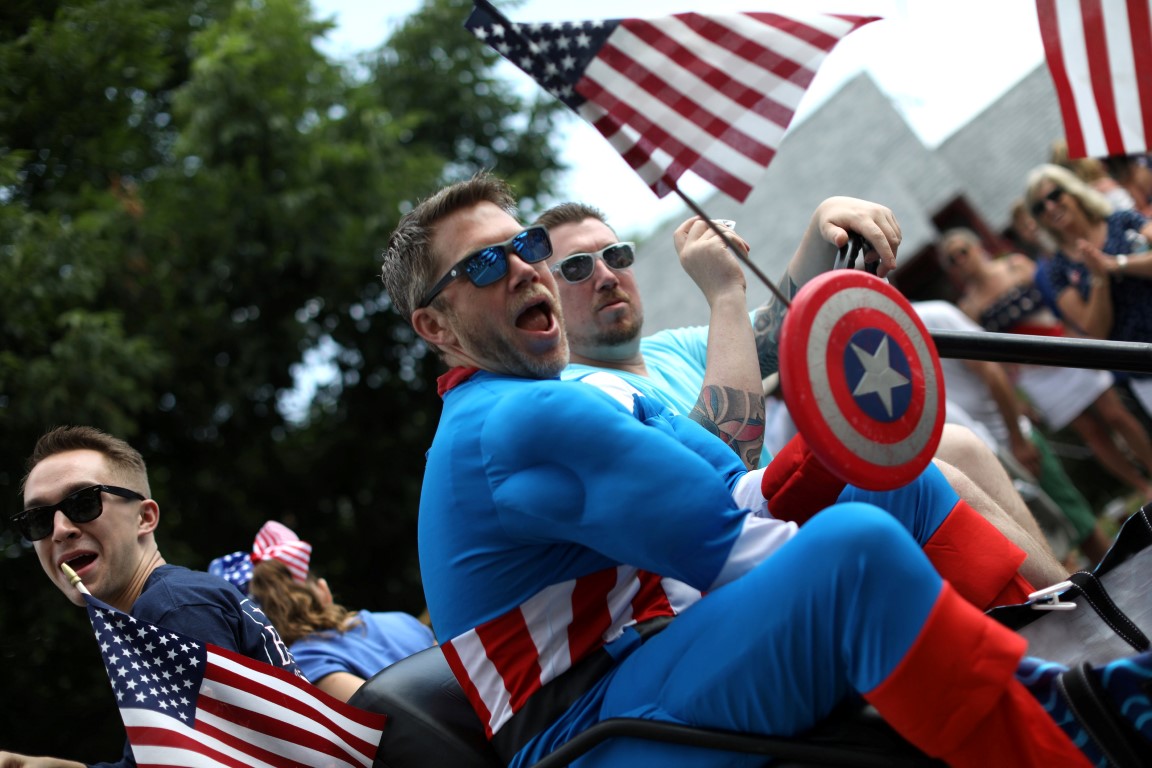 A man in Captain America costume rides down Main Street during the annual Fourth of July parade...