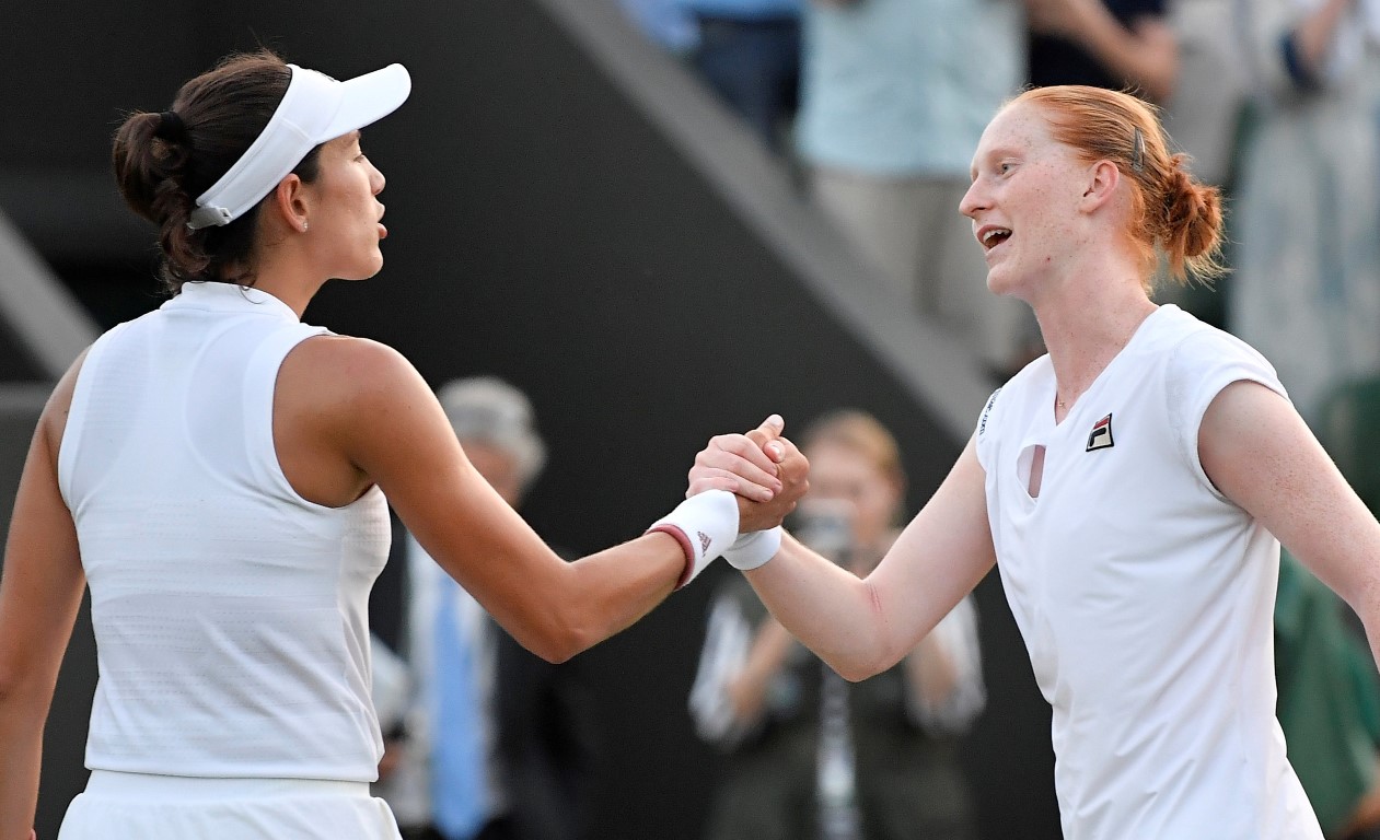 Alison Van Uytvanck (R) shakes hands with Garbine Muguruza after the match. Photo: Reuters