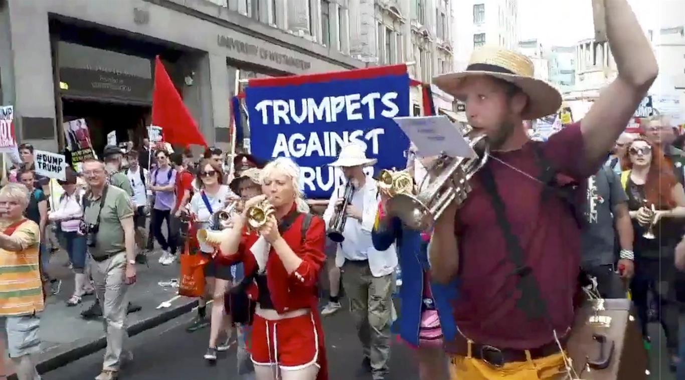 People play trumpets during a "Trumpets Against Trump" protest in London, in this still taken...