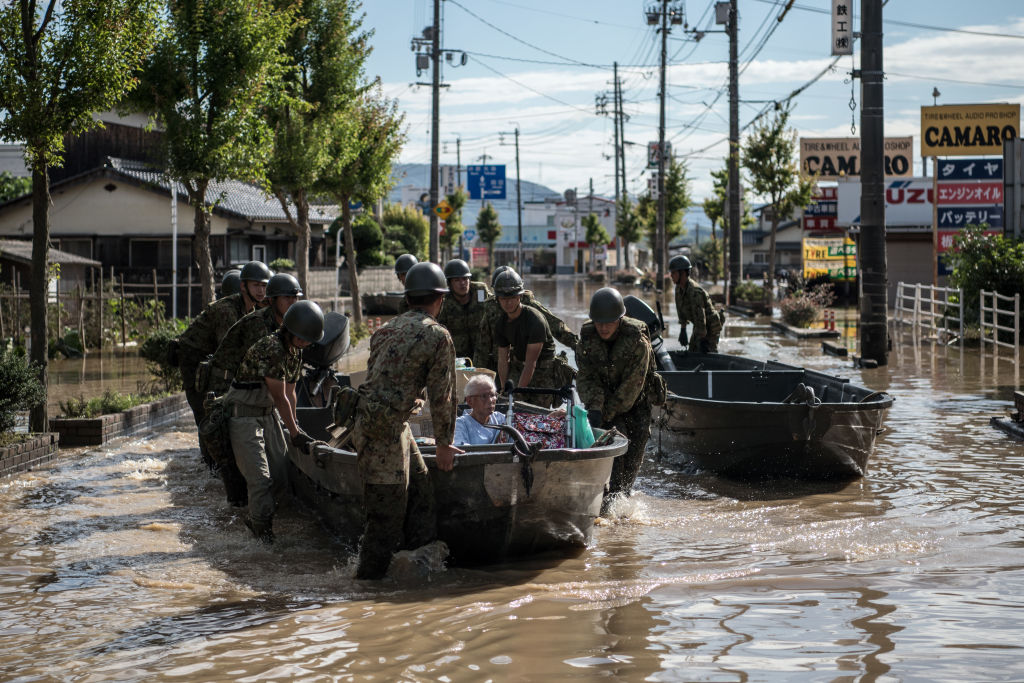 Soldiers ferry elderly people to safety following heavy flooding in Kurashiki near Okayama, Japan...