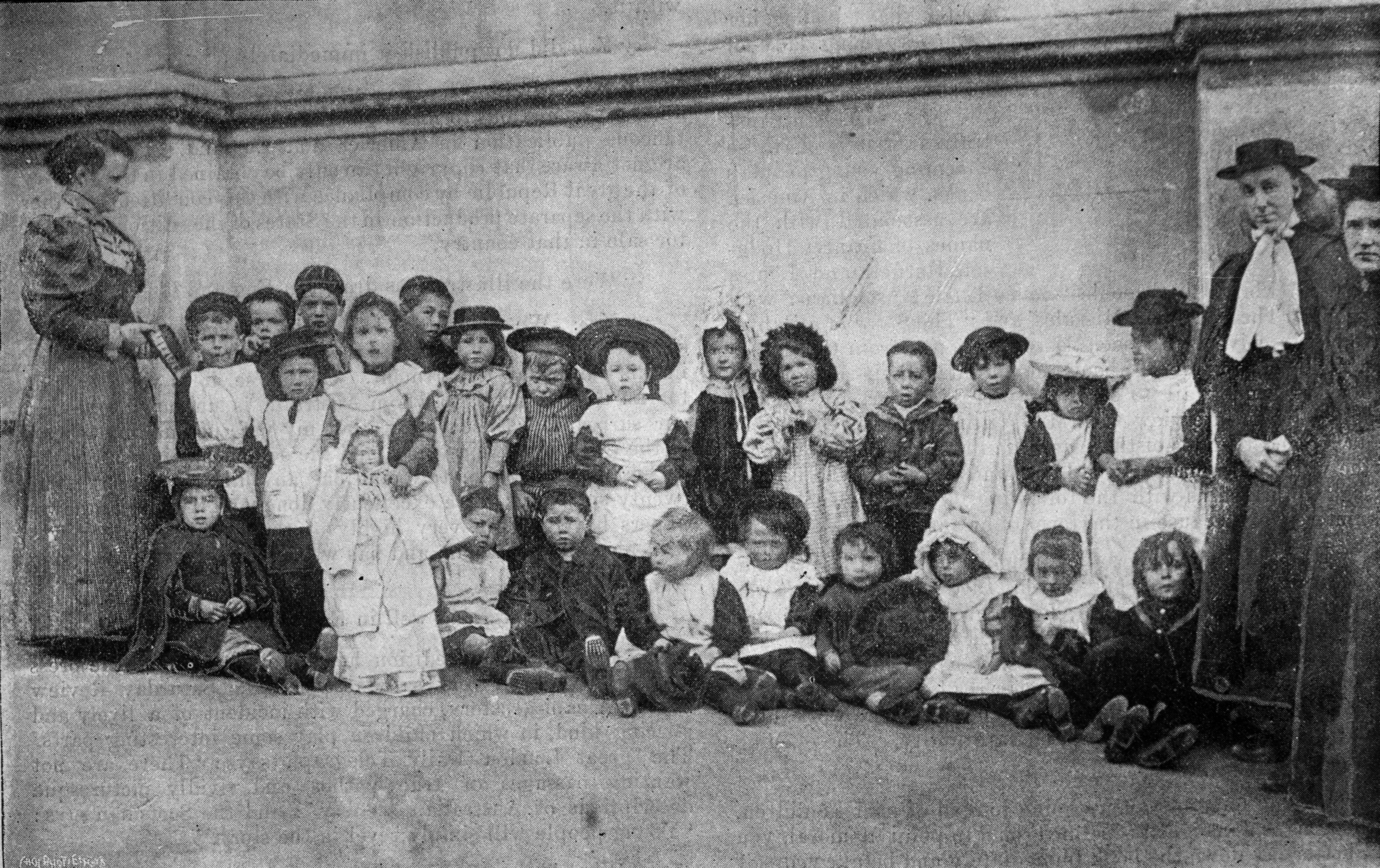 Teachers and children outside the Walker Street Kindergarten in 1895. The "little waifs and...
