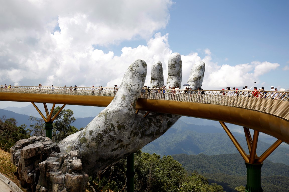 People walk past one of the giant hands on the bridge on Ba Na hill. Photo: Reuters 