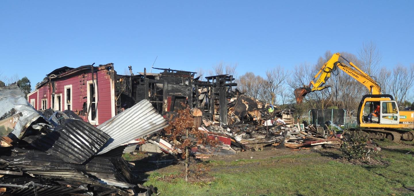 Contractors demolishing Bruce and Jocelyn Buchanan's Waipawa home, after it was destroyed by fire...