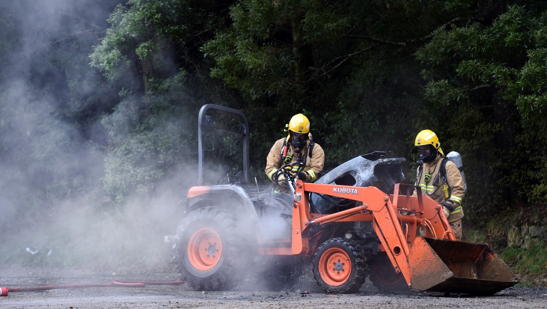 Firefighters extinguish a blaze which started in a tractor this afternoon. Photo: Peter McIntosh