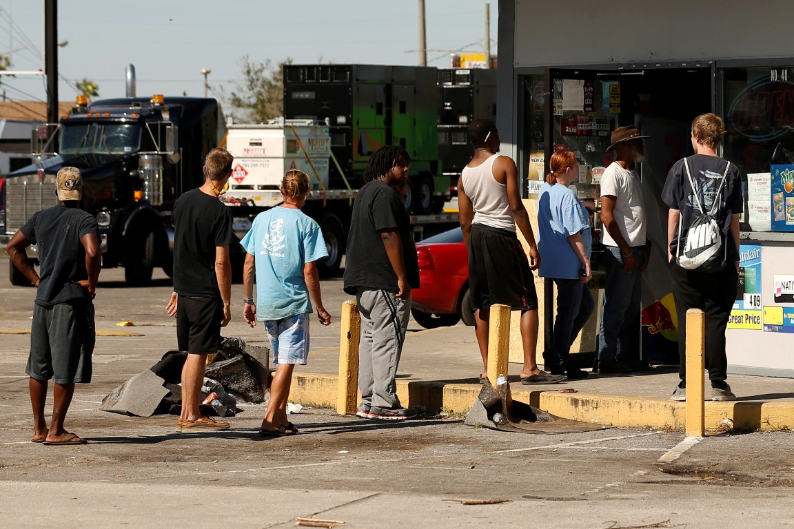 People wait in line to enter a convenience store in Callaway, Florida after Hurricane Michael hit...