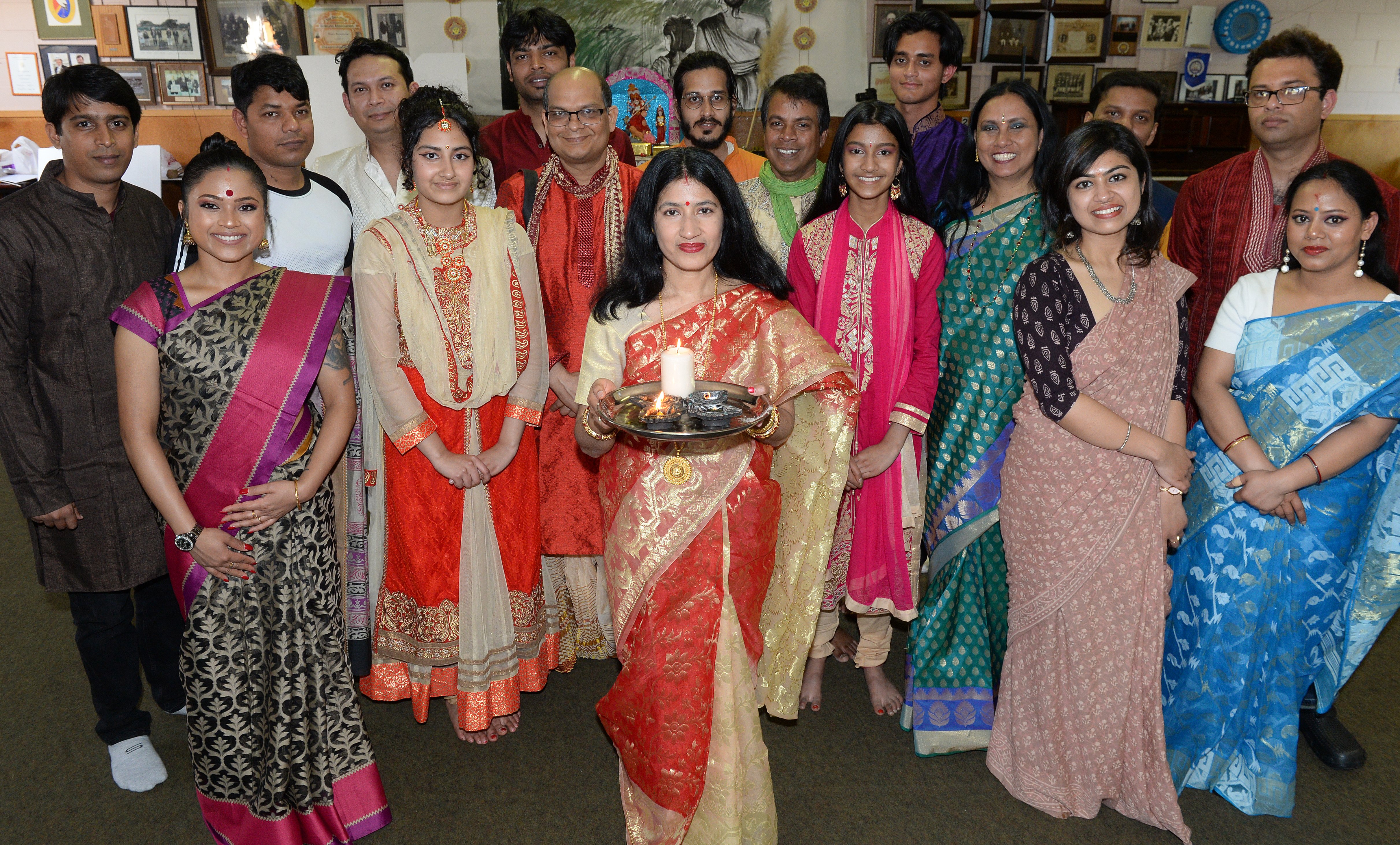 Shubhra Sinha holds a diya lamp, a symbol of universal light, as she marks Durga along with other...