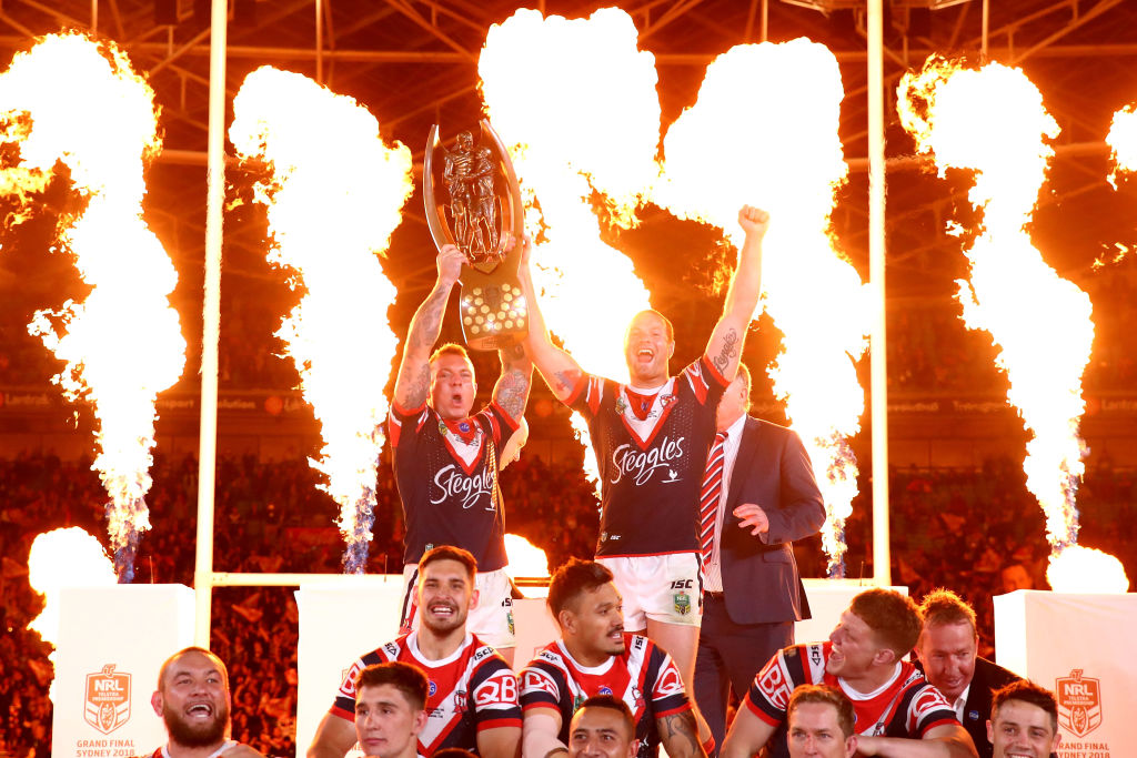 Roosters players celebrate with the trophy after beating the Melbourne Storm in the 2018 NRL...