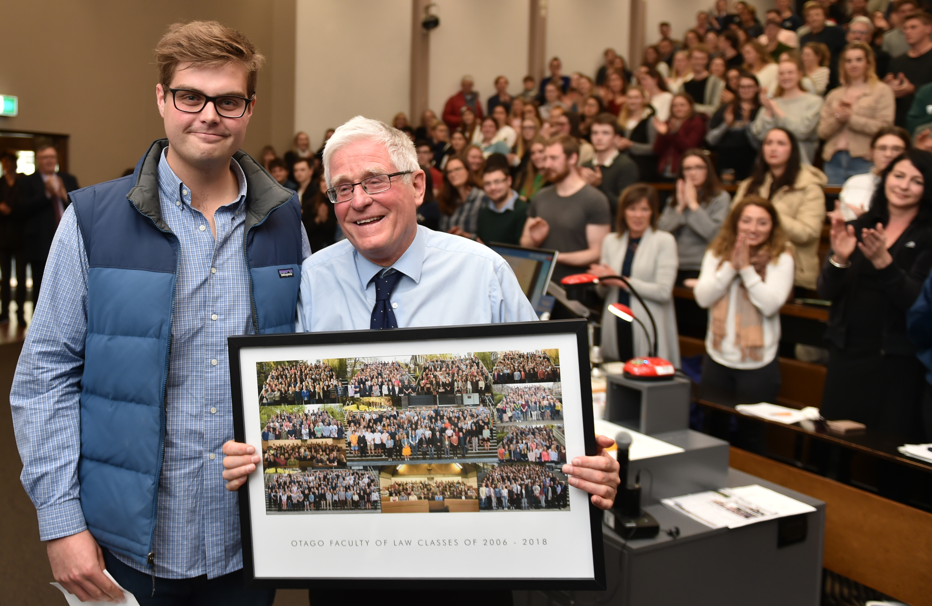 Law student Tim Austen presents lecturer Prof Mark Henaghan with a board of finalists' pictures...