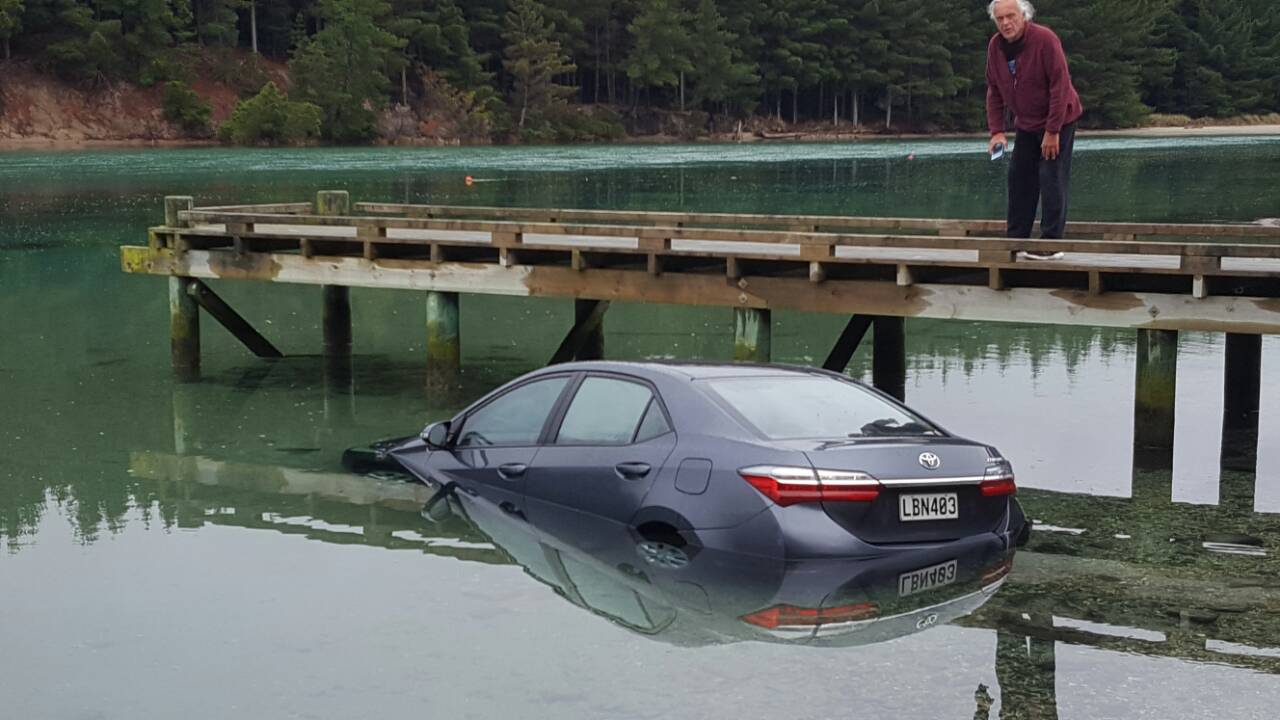 A rental car had to be abandoned after it was driven into the Purakaunui inlet during low tide and became stuck in the sand. Photo: Jude Newton