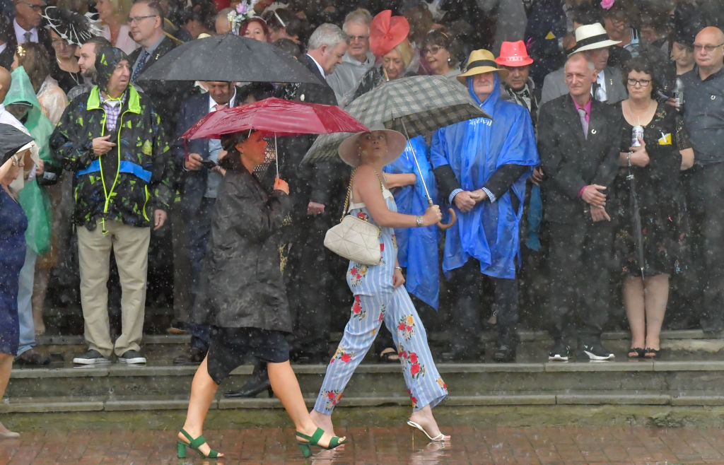Racegoers brave the rain at Flemington Racecourse. Photo: Getty  