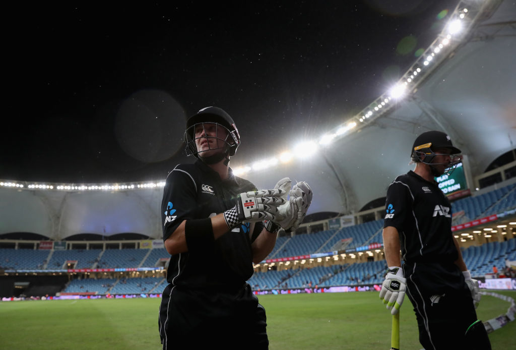 New Zealand batsmen George Worker and Henry Nicholls leave the field as rain stops play during...