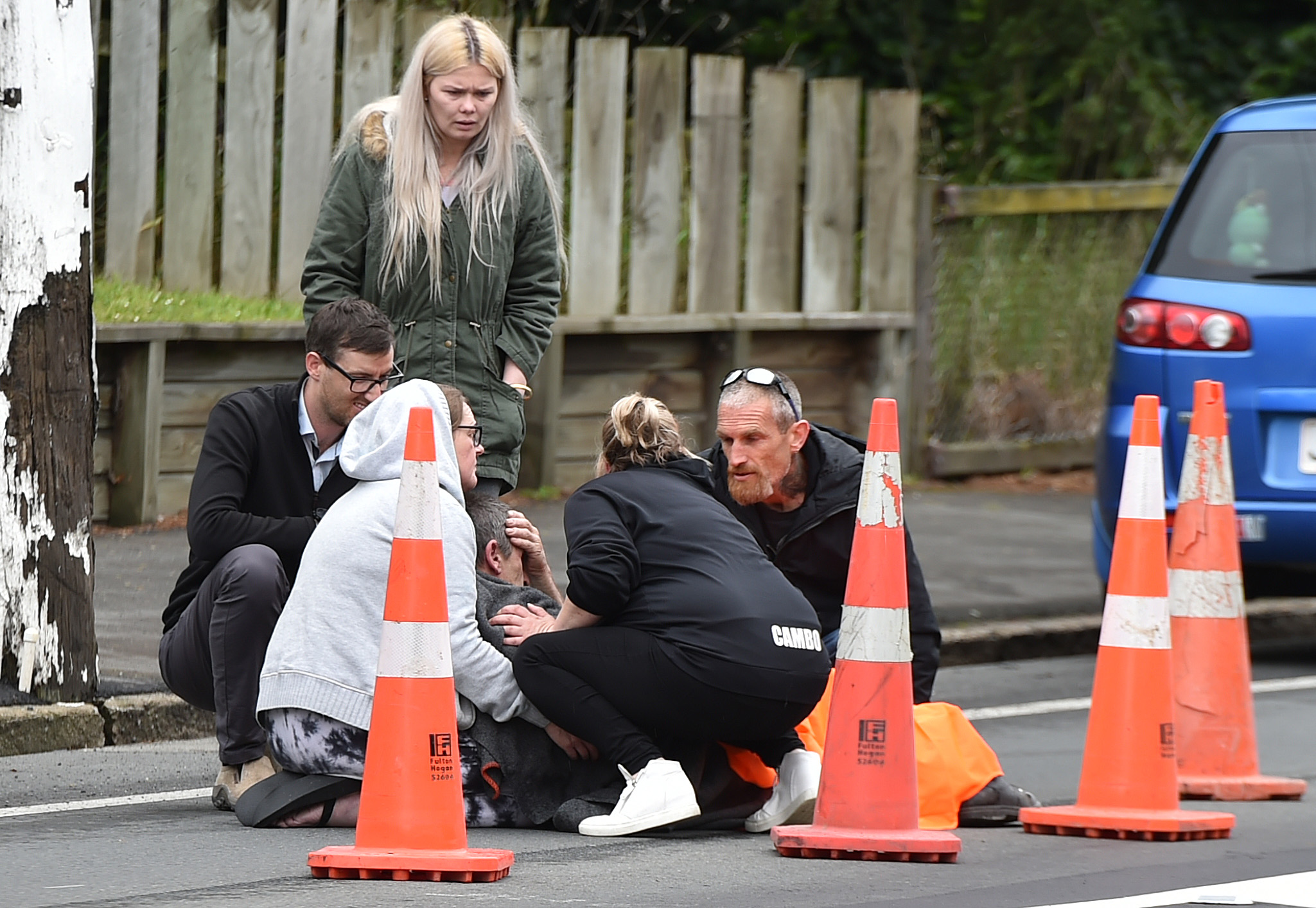 Members of the public assist a man after the incident in Halfway Bush. Photos: Gregor Richardson