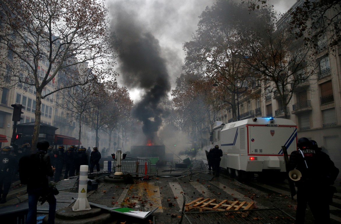 Riot police stand guard near a barricade during clashes with protesters at the Place de l'Etoile...