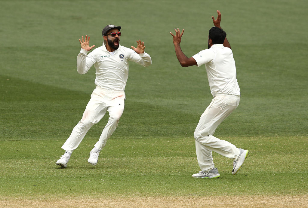 India's Virat Kohli (L) and Ravi Ashwin celebrate their victory at the fall of the final...