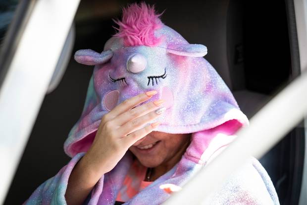A woman covers her face when approached by the New Zealand Herald. Photo: NZME