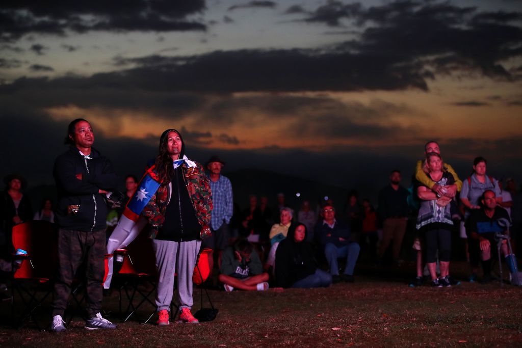 People watch the Waitangi Day Dawn Service as the sun rises at the Whare Runanga in Waitangi....