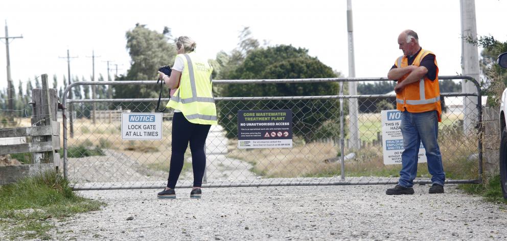 A WorkSafe New Zealand official, watched by another official, examines a gate through which the...