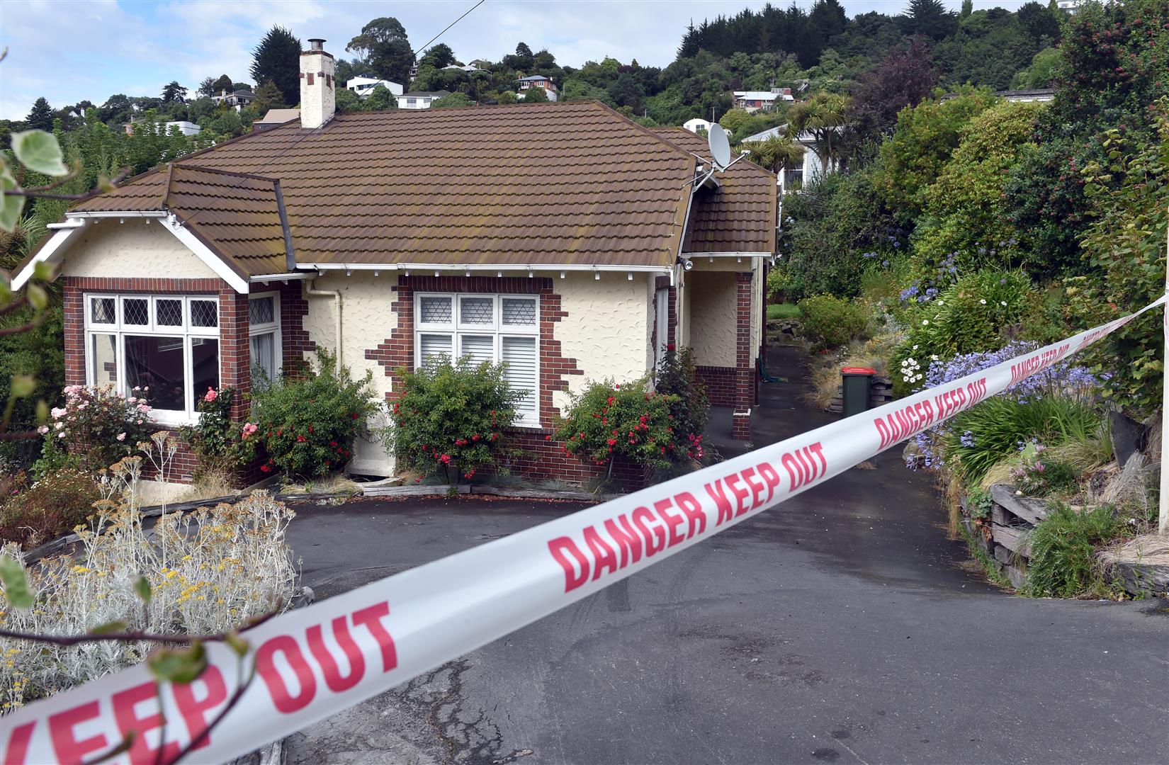 A slip underneath this Allandale Rd property, is still moving and it is not yet known when the five other neighbouring properties, also considered dangerous buildings, can be occupied again. Photos: Peter McIntosh