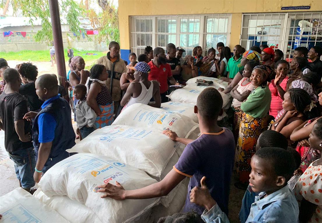 People arrive for food distribution at a school that has been turned into a shelter in Beira,...