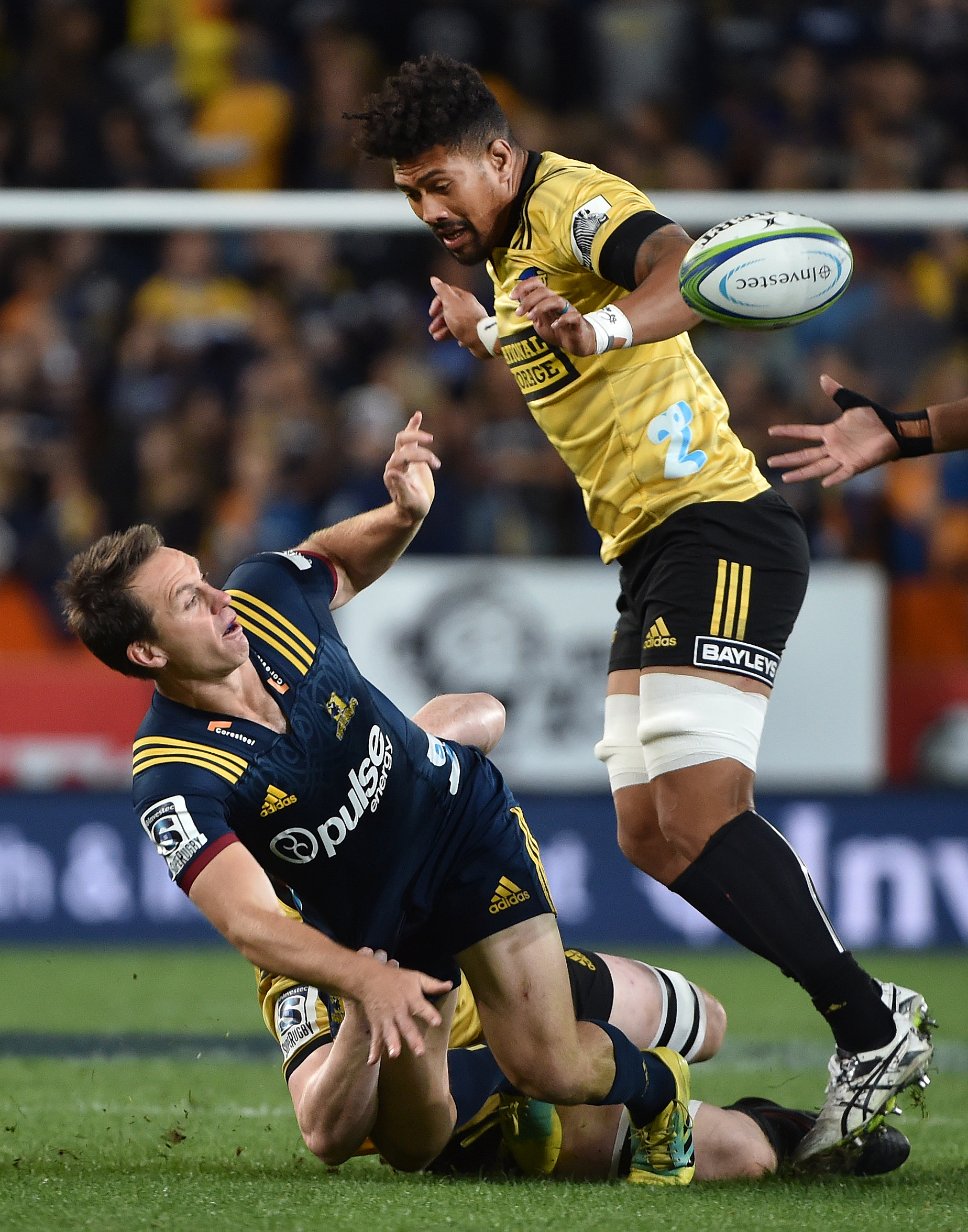 The Highlanders' Ben Smith is tackled by Hurricanes lock James Blackwell while Hurricanes flanker...