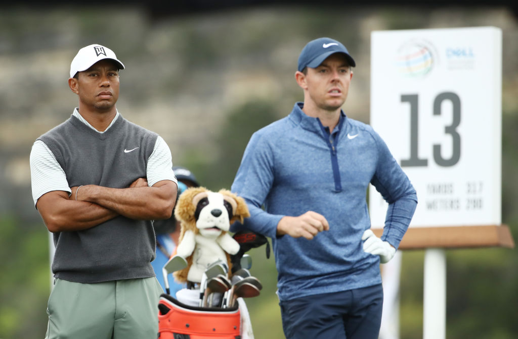 Tiger Woods (L) and Rory McIlroy on the 13th tee during the fourth round of the World Golf...
