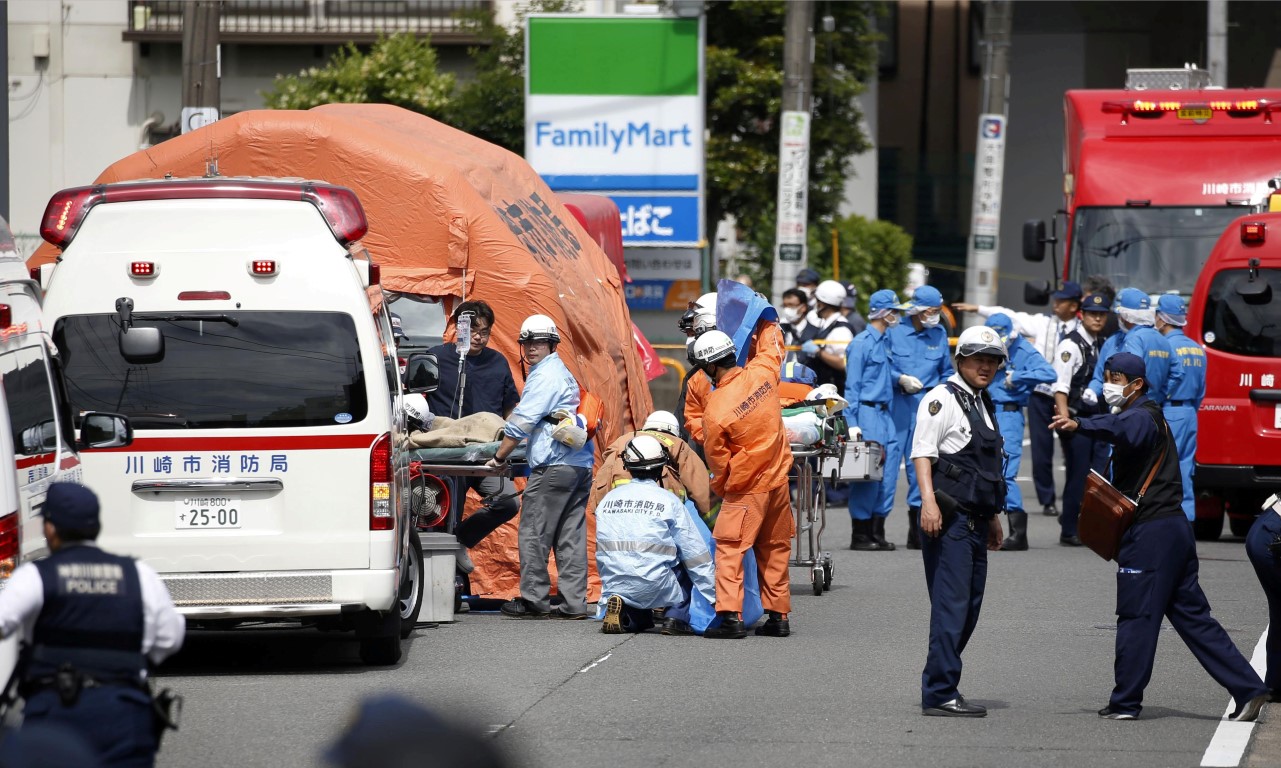 Rescue workers and police officers at the scene after the attack. Photo: Kyodo/via REUTERS