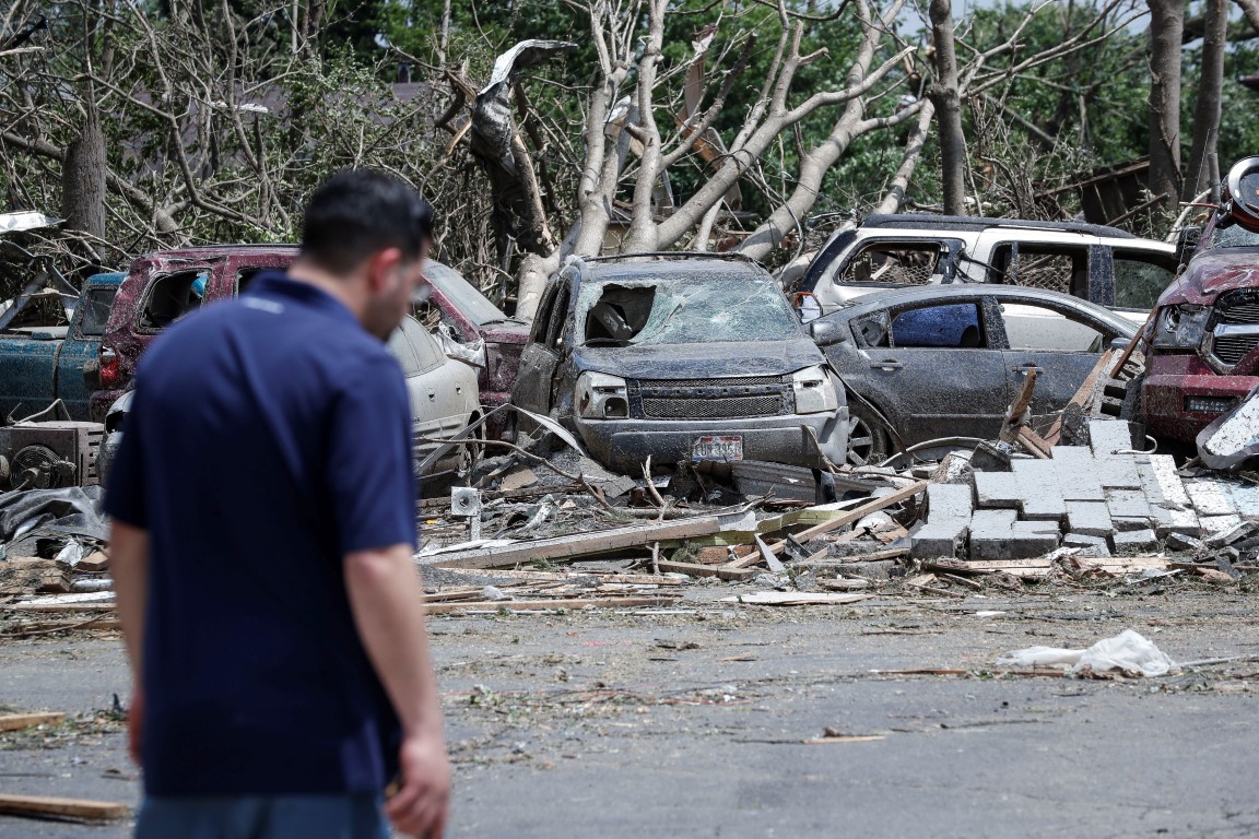 People walk past storm debris on North Dixie Drive in Dayton, Ohio, after the tornadoes hit....
