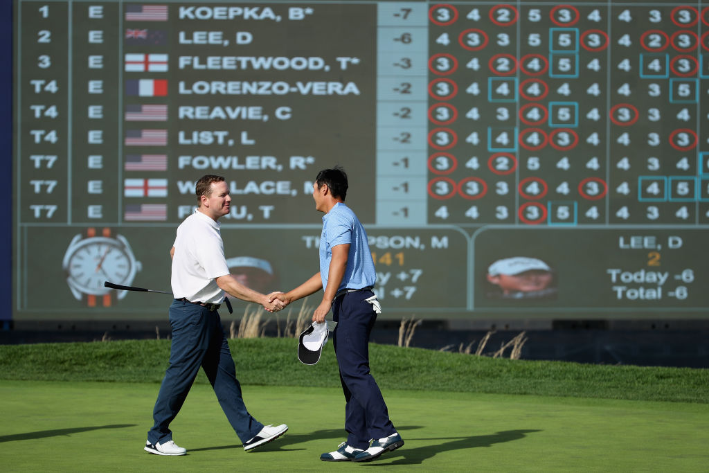 Danny Lee (R) shakes hands with Justin Bertsch on the 18th green at the end of the first round....