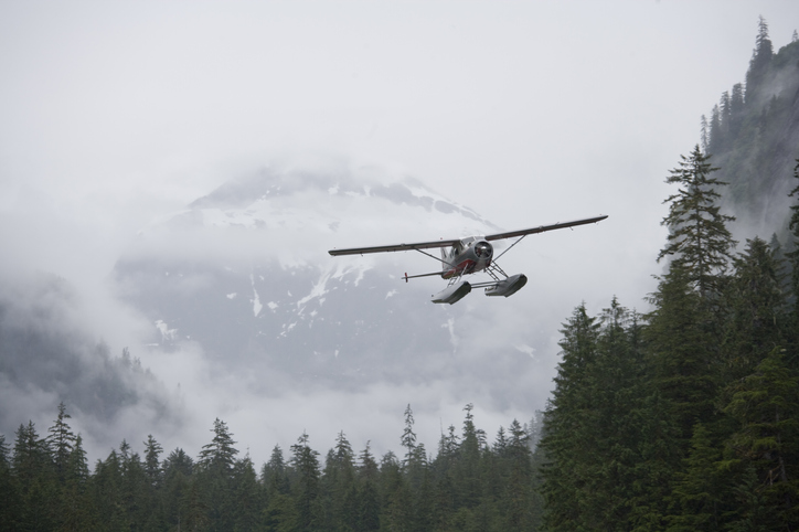 A floatplane flies low in the Misty Fjords National Monument area in Alaska. Stock photo: Getty