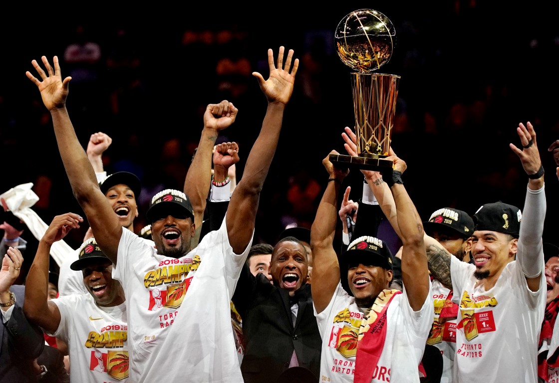 Toronto Raptors players celebrate with the Larry O"Brien Trophy after beating the Golden State...