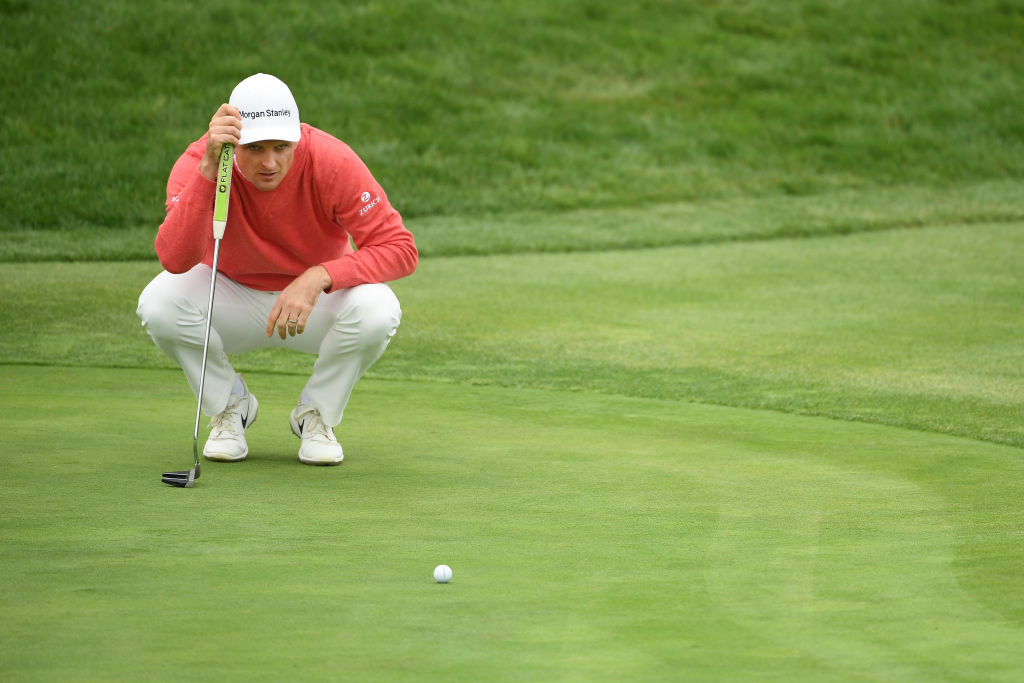 Justin Rose lines up a putt on the 12th green. Photo: Getty